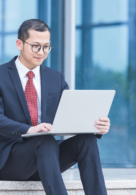 Business men use laptops at the entrance of an office building