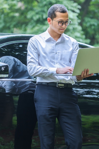 Free Photo business men work with laptops on the side of the car