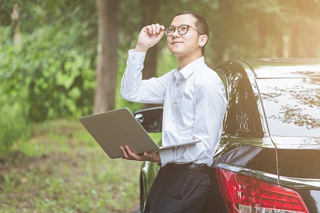 Free Photo business men work with laptops on the side of the car