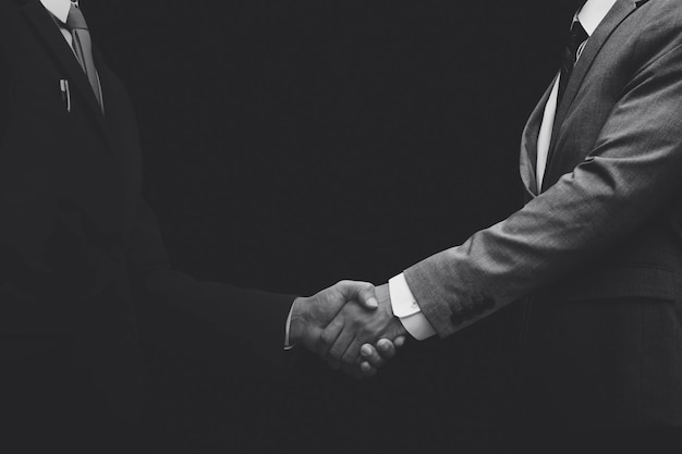 Free Photo business partners shaking hands monochrome