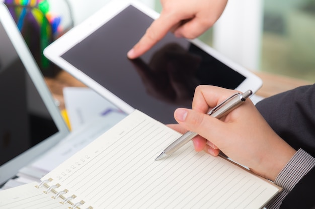 Business people comparing results on a tablet