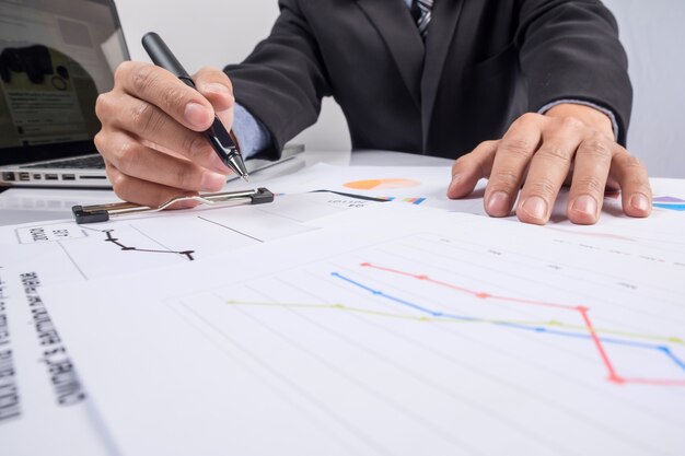 Business people discussing financial charts - closeup shot of hands over table