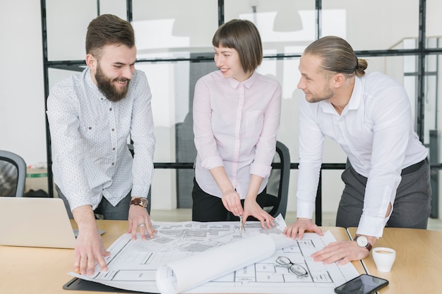 Free photo business people looking at plans in office