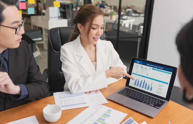 business people meeting Stock brokers looking at graphs indexes on laptop screen at office