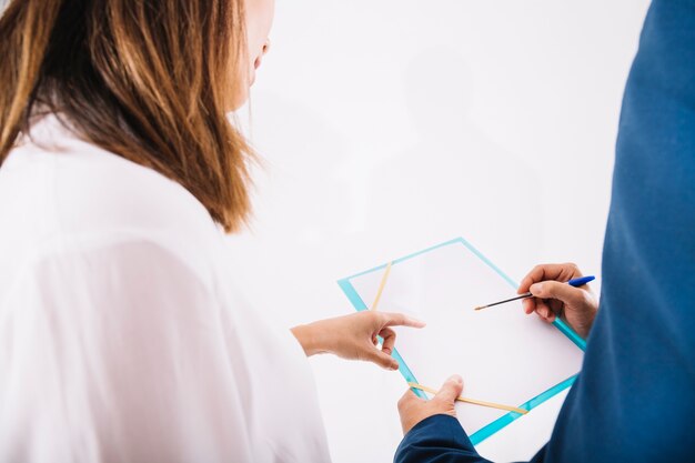 Business persons writing on clipboard