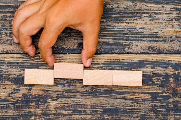 Free photo business strategy concept on wooden background flat lay. hand pulling wooden block.