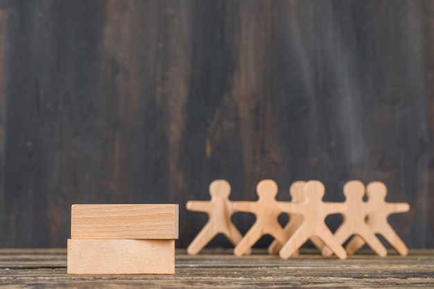 Free photo business success concept with wooden blocks, human figures on wooden table side view.