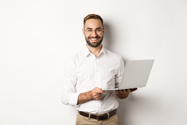 Free photo business. sucessful businessman working with laptop, using computer and smiling, standing