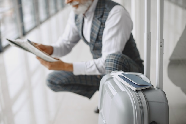 Business trip. Corporate and people concept. Male in a gray coat. Senior with a map.