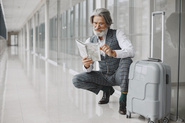 Free photo business trip. corporate and people concept. male in a gray coat. senior with a map.