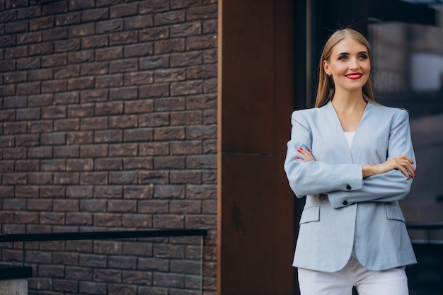 Free photo business woman in blue jacket by the office center