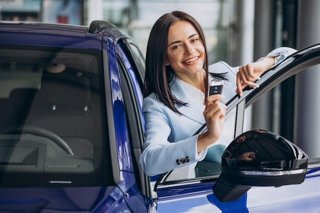 Free photo business woman choosing a car in a car showroom