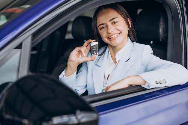 Business woman choosing a car in a car showroom