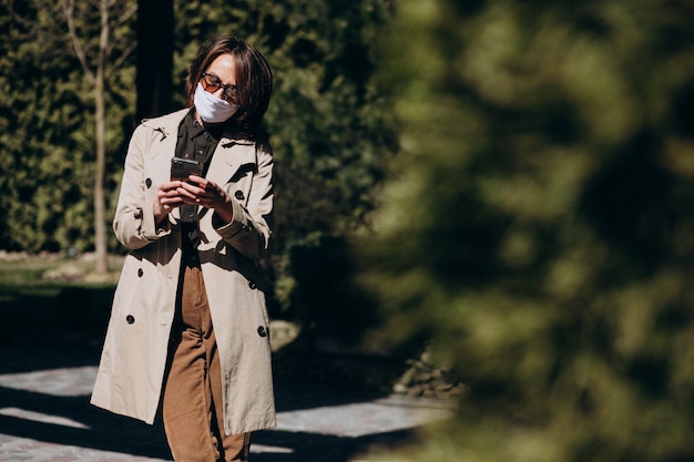 Free Photo business woman in coat using phone outside