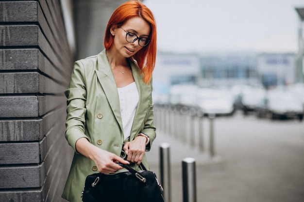 Free Photo business woman in green suit standing by the wall