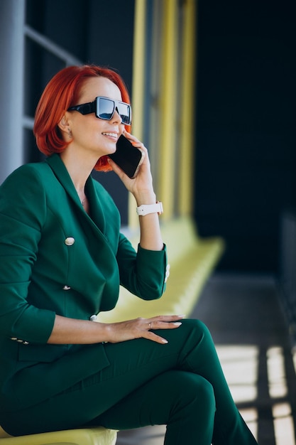 Business woman in green suit using phone