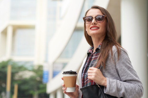 Business woman heading off to work with takeaway coffee in the morning