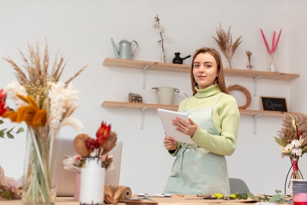 Business woman holding a digital tablet in her own shop