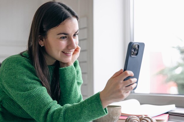 Business woman in the morning in the kitchen with a smartphone