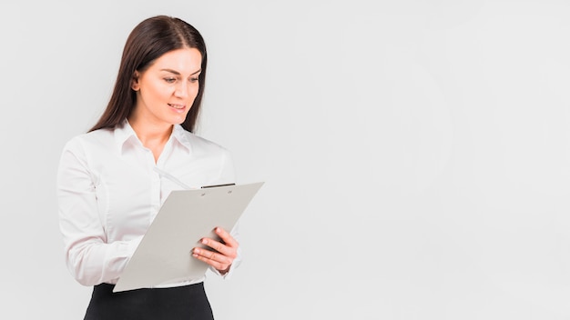 Business woman in shirt writing on clipboard