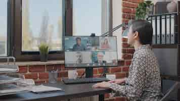 Free photo business woman talking to colleagues on online video call, doing teamwork on project planning. person using remote video conference to have conversation about development. teleconference