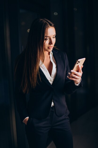 Business woman talking on the phone and staying late at night at the office