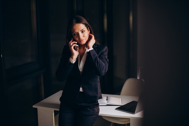 Free photo business woman using phone in office and staying late by night