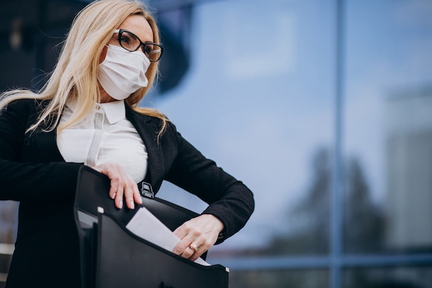 Free Photo business woman wearing mask outside the business center