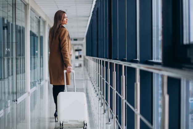 Free photo business woman with travel bag in airport