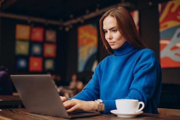 Business woman working on laptop in a cafe