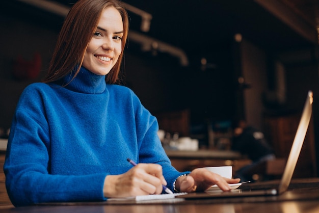 Business woman working on laptop in a cafe