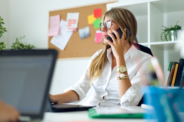 Free Photo business woman working with mobile phone in her office.