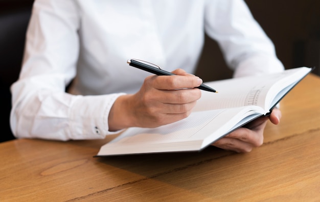 Business woman writing in agenda