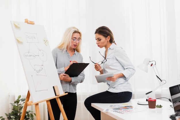 Free Photo business women looking on a clipboard