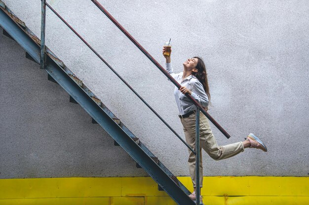 Business young woman near the stairs with a cup of coffee