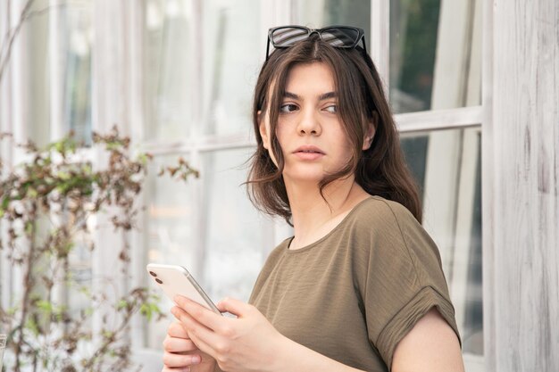 Business young woman with a smartphone in her hands on a hot summer day