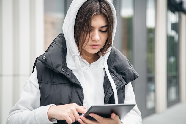 Free photo business young woman with a tablet on the background of the building