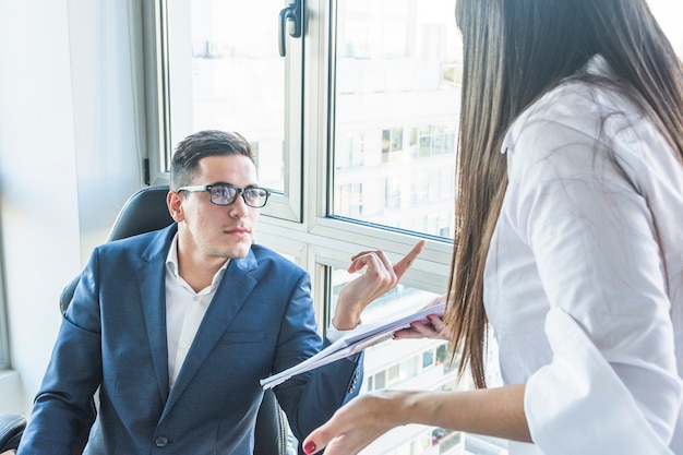 Businessman asking questions to businesswoman in the office