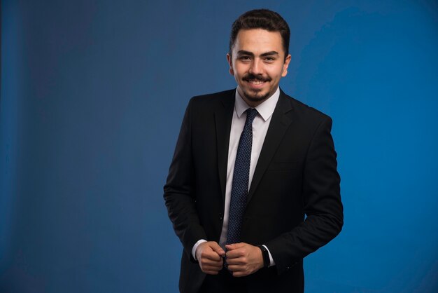 Businessman in black suit greeting someone. 