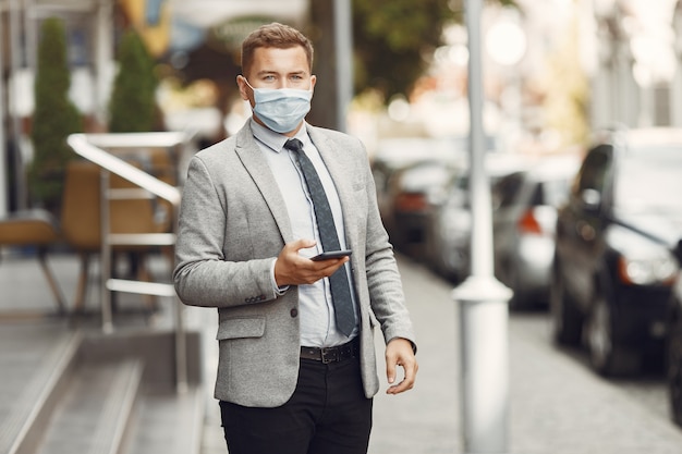 Businessman in a city. Person in a mask. Guy with phone.