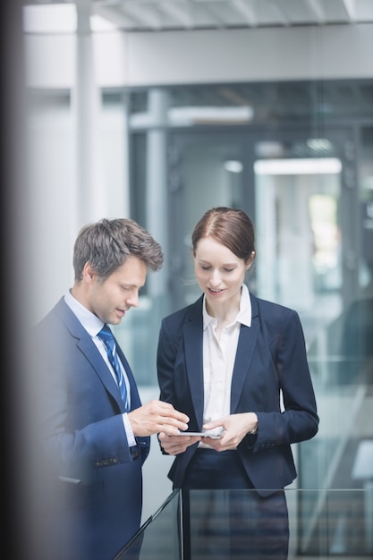 Businessman and colleague discussing over digital tablet