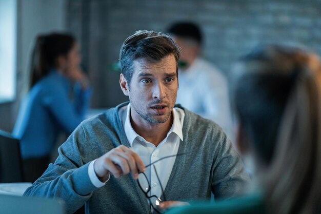 Businessman communicating with a coworker while working in the office