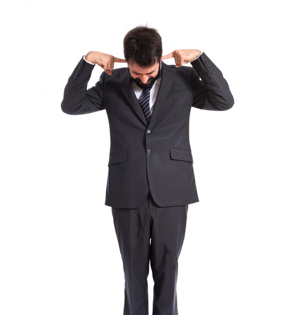 Businessman covering his ears over white background