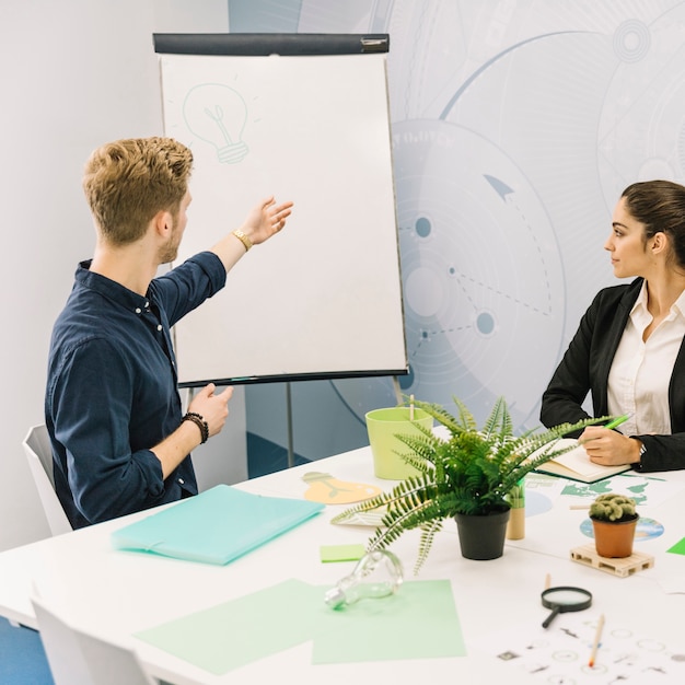 Free Photo businessman discussing energy saving concept with his colleague on flipchart