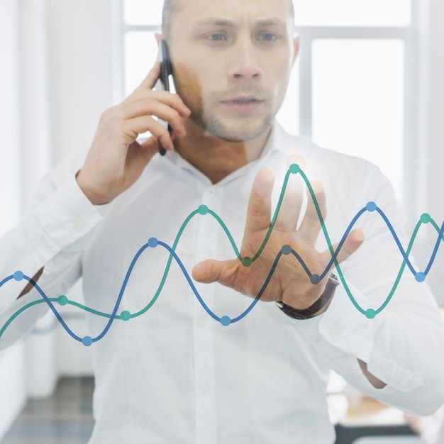 Free Photo businessman doing phone call and looking at charts