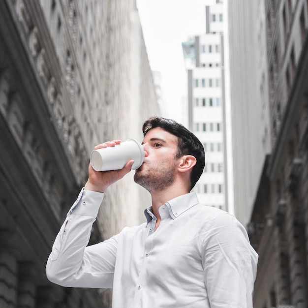 Businessman drinking on city street