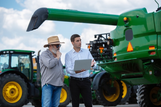 Businessman and farmer with tractors