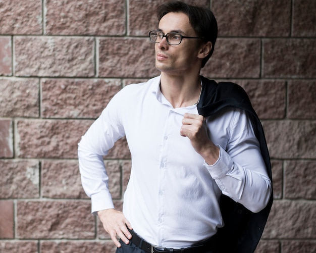 Free Photo businessman in front of brick wall