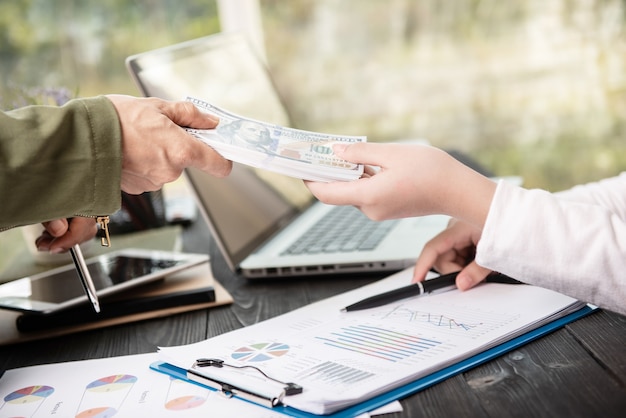 Businessman giving money to his partner while making contract