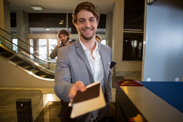 Businessman handing over his boarding pass at counter